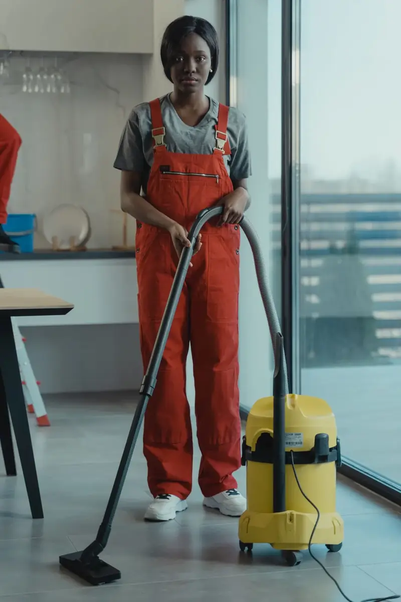Reinigungskraft saugt den Boden in einem hellen Büro